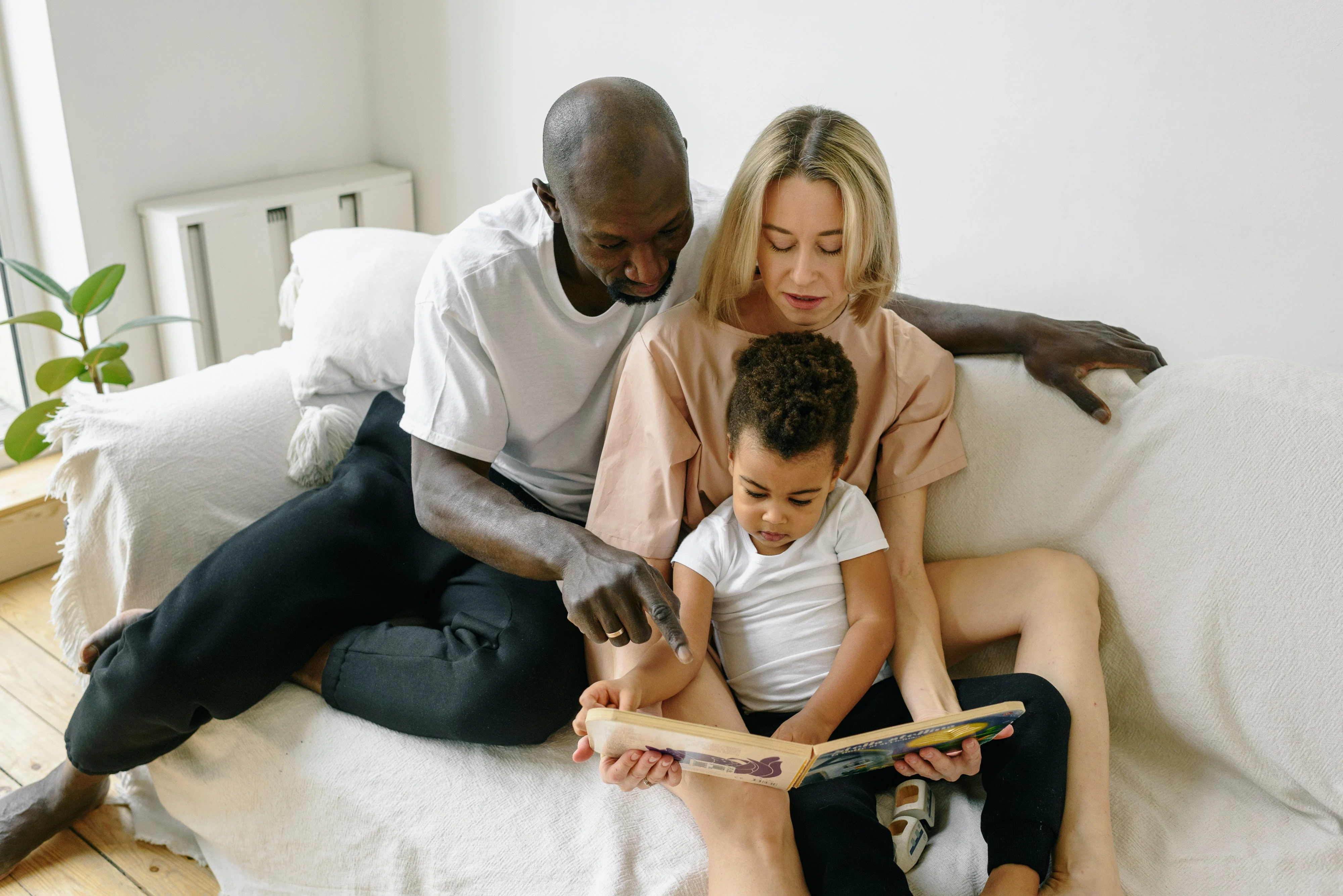 family on a couch reading a book